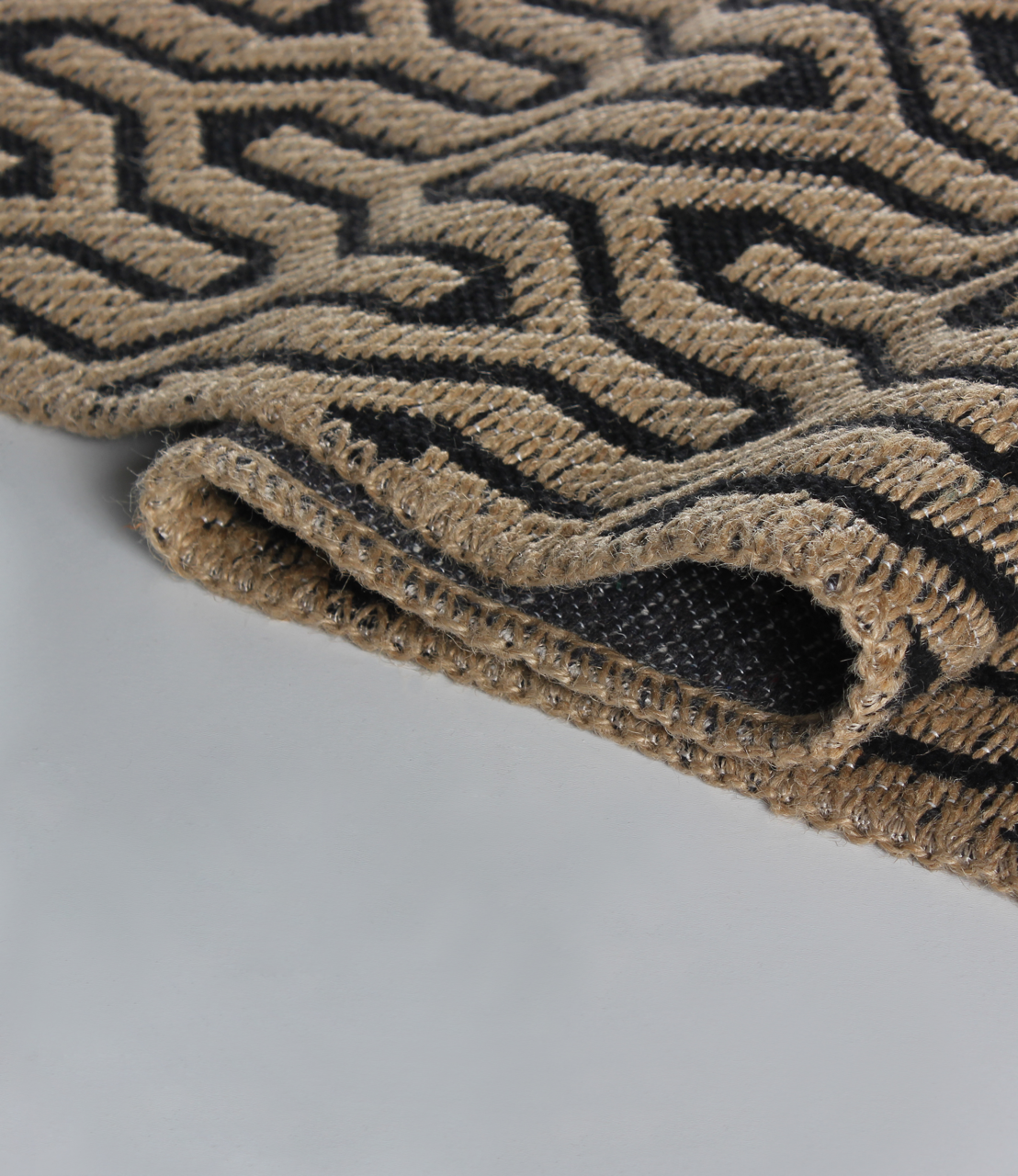 Natural jute geometric rug by Netline Home, washable flatweave eco-friendly carpet with beige and black pattern and cotton backing.