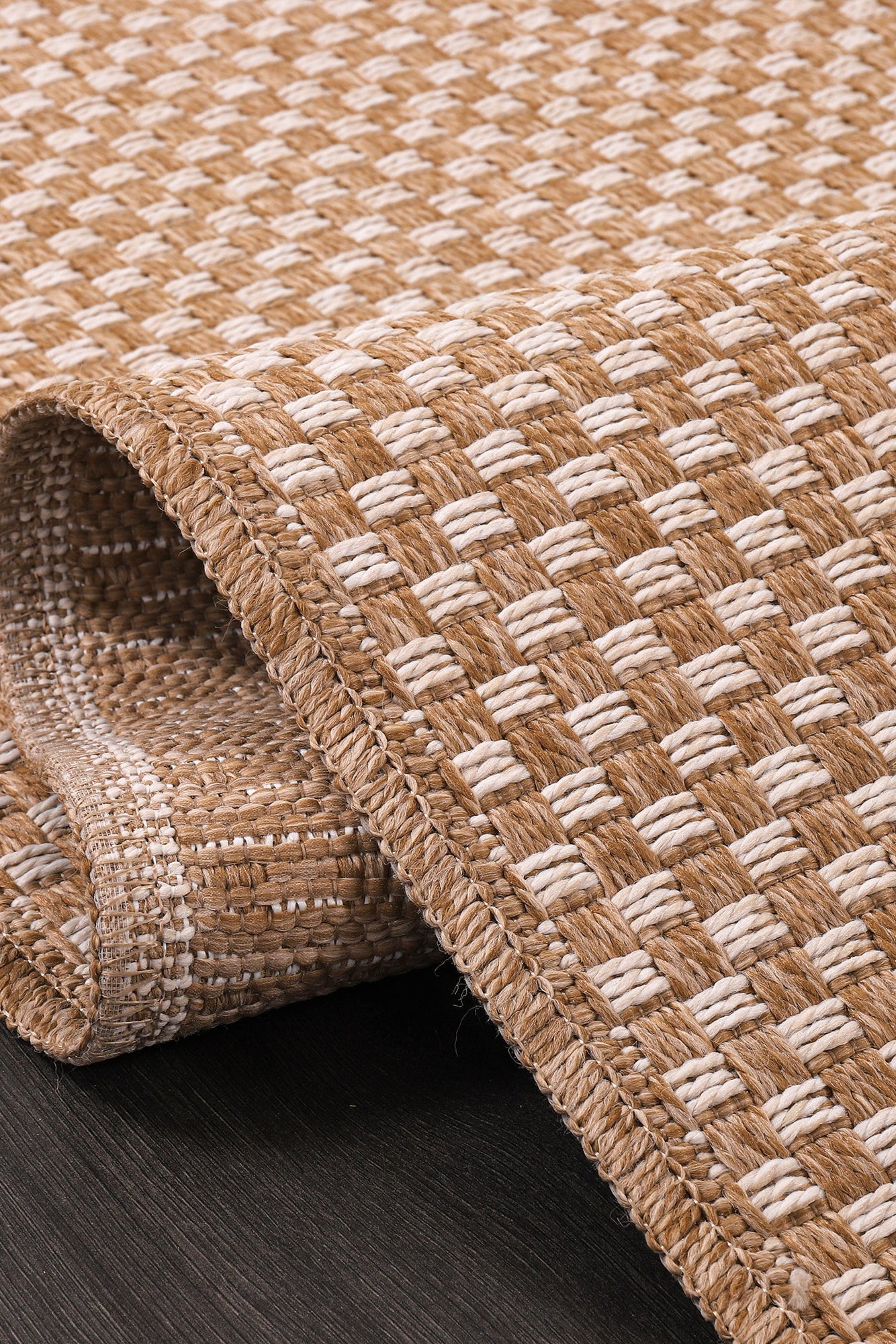 Close-up of a woven jute rug on a dark wooden floor