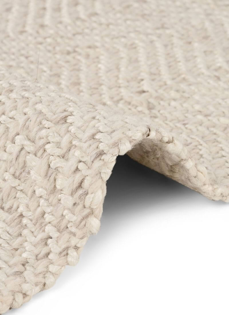 Natural white herringbone wool and jute runner rug from The Rugs, showcasing a textured pattern and soft fibers.