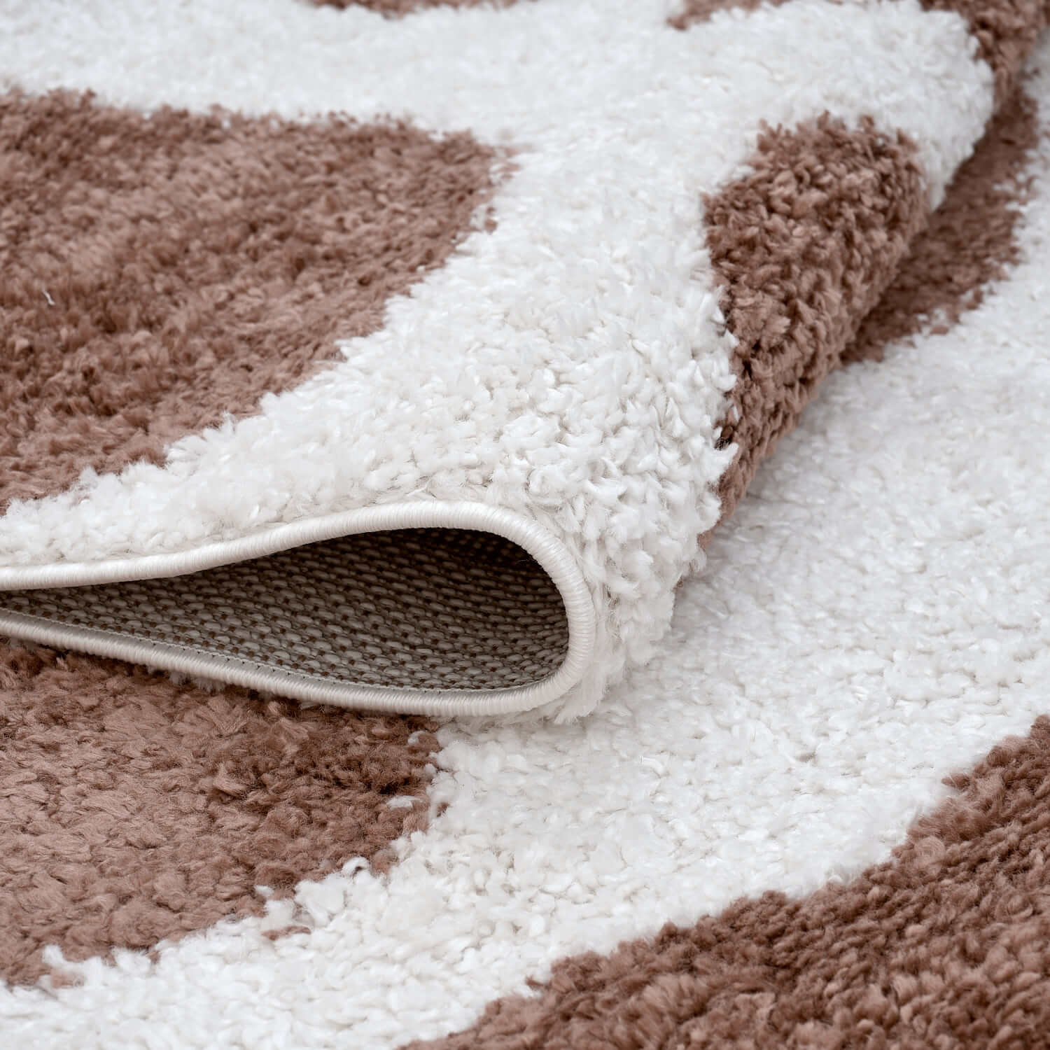 Moodi Shaggy Terra Froth Runner Rug from The Rugs, folded to show soft, plush shaggy texture in warm earth tones.