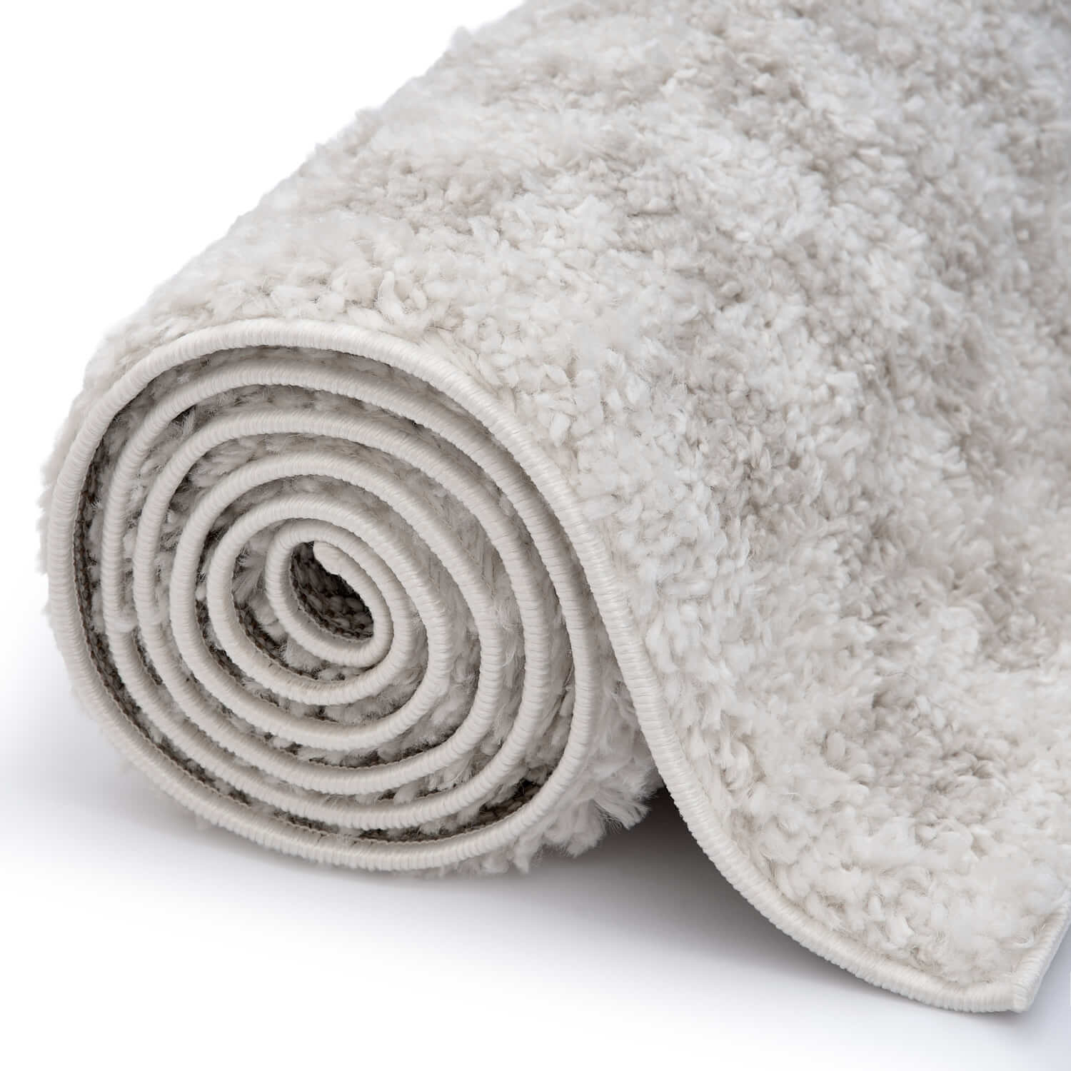 Light beige Moodi Nomari shaggy runner rug by The Rugs, rectangular and rolled, showcasing its soft, textured surface and modern design.